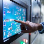 close up of an inspector working on touch screen of production machine.